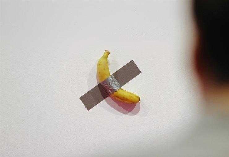 Südkoreanischer Kunststudent ißt Banane die Teil einer Installation des Künstlers Maurizio Cattelan war