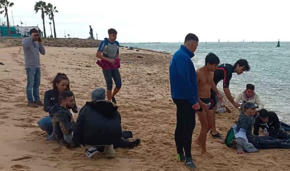 Das Schiff befand sich in der Nähe der andalusischen Küste, als Passagiere, vermutlich aus Nordafrika, offenbar über Bord gestoßen wurden. Einheimische helfen Migranten, die überlebt haben, als sie in der Nähe von Cádiz, Spanien, vom Schnellboot gezwungen wurden.